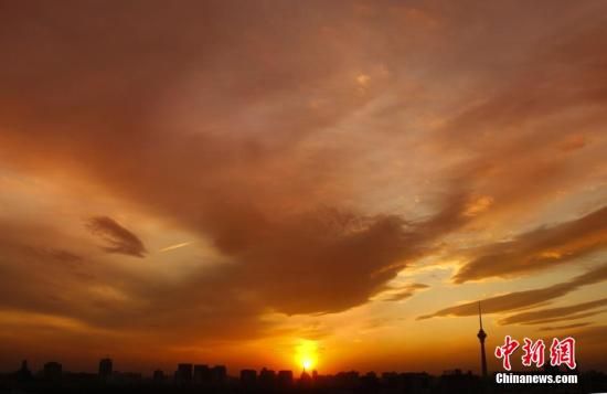 12月8日下午，強(qiáng)烈的西北風(fēng)光臨北京，吹散了籠罩全城上空的霧霾，冬日罕見(jiàn)的艷麗晚霞映紅了半邊天。