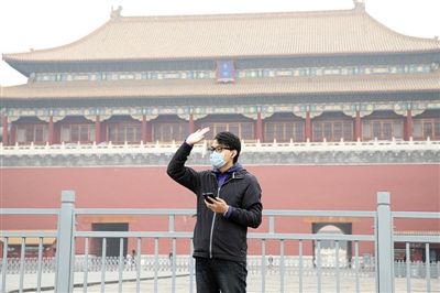 11月1日，北京大部分地區(qū)重度污染，一名游客戴著口罩在午門(mén)前揮手跟朋友打招呼。 實(shí)習(xí)生 王飛 攝