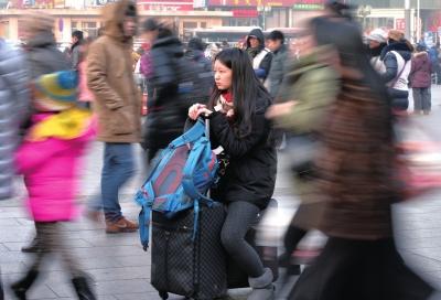 春運(yùn)首日，北京站客流量明顯增多，一名女孩在人流中等待進(jìn)站。