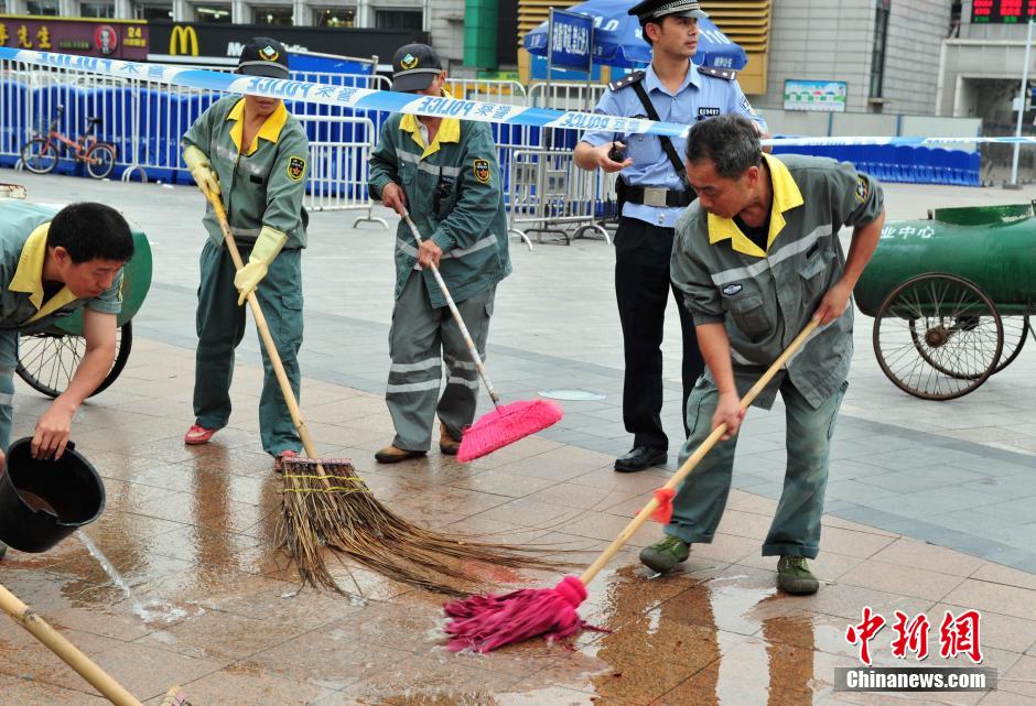 圖為環(huán)衛(wèi)工人在清理案發(fā)地點的血跡。