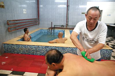 客人在搓澡。近日，百年歷史的鑫園浴池宣布將關(guān)張。新京報記者