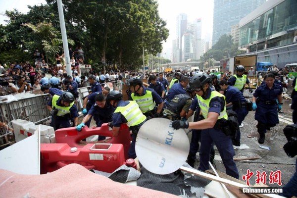 10月14日，警方清除金鐘道障礙物。大批警員在金鐘道現(xiàn)場清拆障礙物。部分警員戴上頭盔將障礙物移走。