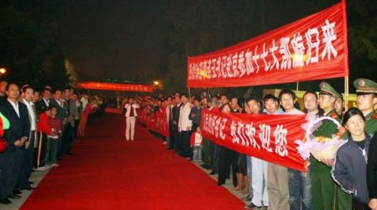 “夾道歡迎”中不少人打出橫幅，路上被鋪上了紅毯。