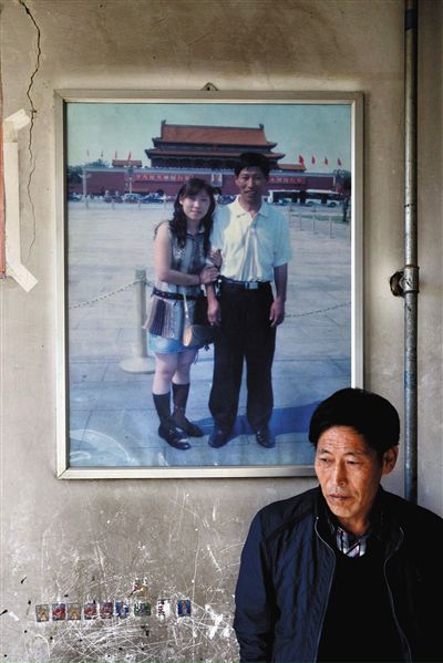 11月14日，承德市平泉縣，潘小梅父母的家，潘小梅父親靠在墻上，身后掛著數(shù)年前他和潘小梅在北京的合影照片。新京報記者