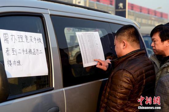 1月23日，北京亞運(yùn)村汽車交易市場中拓拍賣停車場上人頭攢動(dòng)，市民查看拍賣車輛信息。