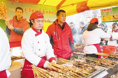 賣羊肉串?dāng)偽焕习遐w山（穿紅衣者）。新京報記者