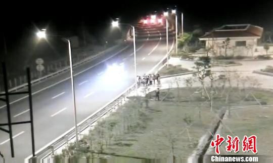 看到車輛經(jīng)過，孩子們便急忙跑到一旁的花圃上?！【焦﹫D　攝
