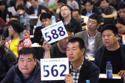 昨日，拍賣現(xiàn)場競拍者舉牌競拍。新京報記者