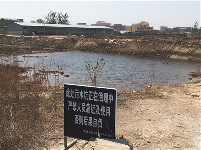 化肥廠滲坑的三分之一經(jīng)過治理，但水質(zhì)仍然呈黃褐色。