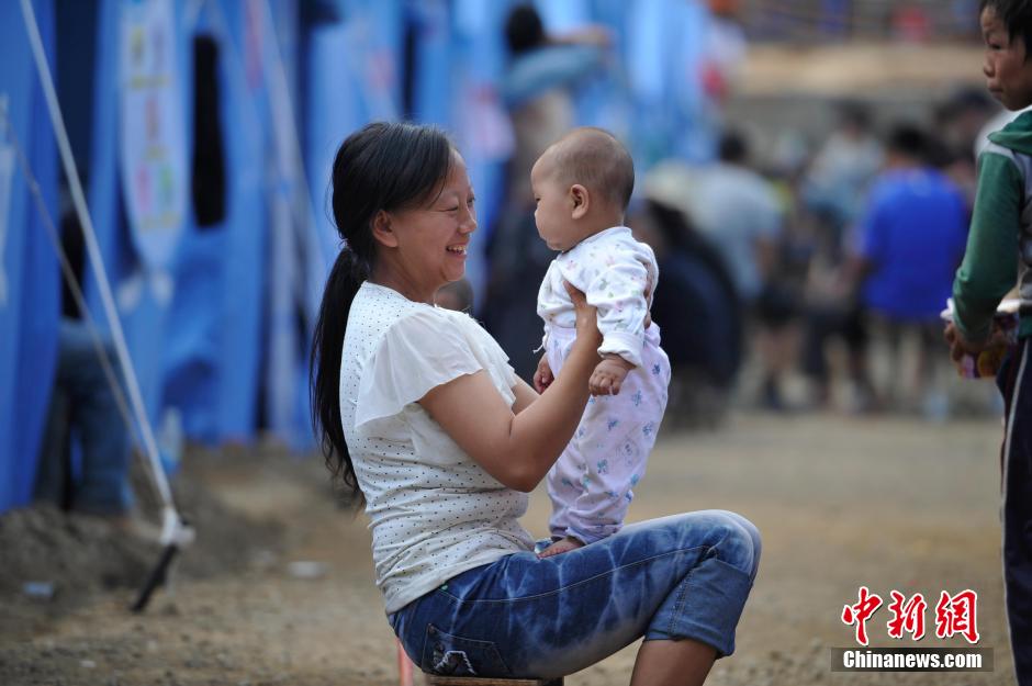 8月6日，一名年輕的母親在和孩子玩樂。