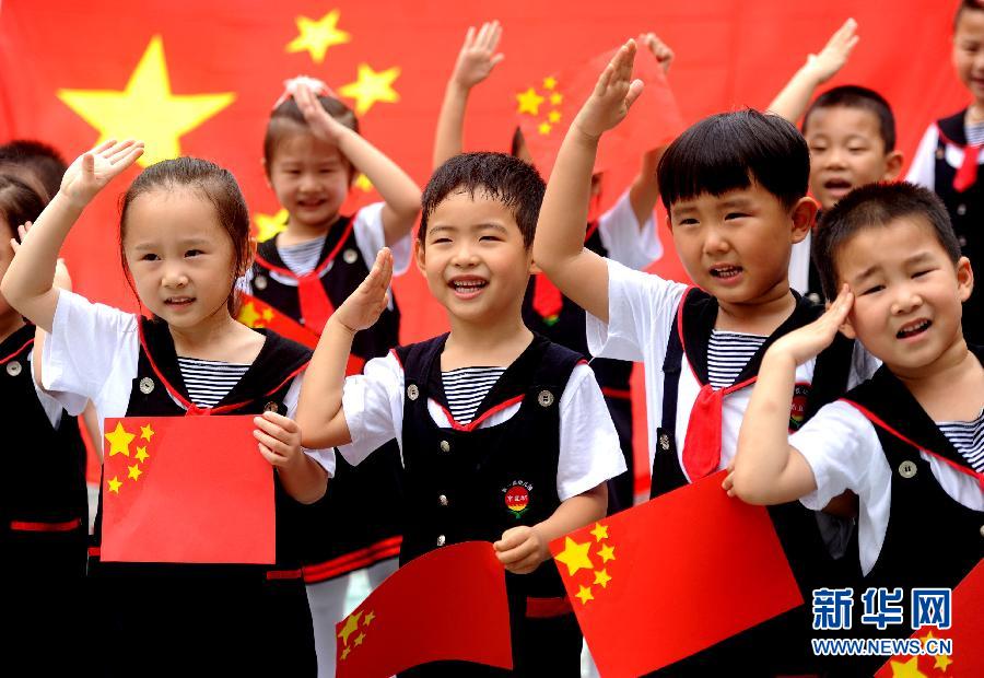  9月28日，安徽淮南市直機關幼兒園的小朋友在國旗前唱《國歌》，慶祝祖國65周歲生日。