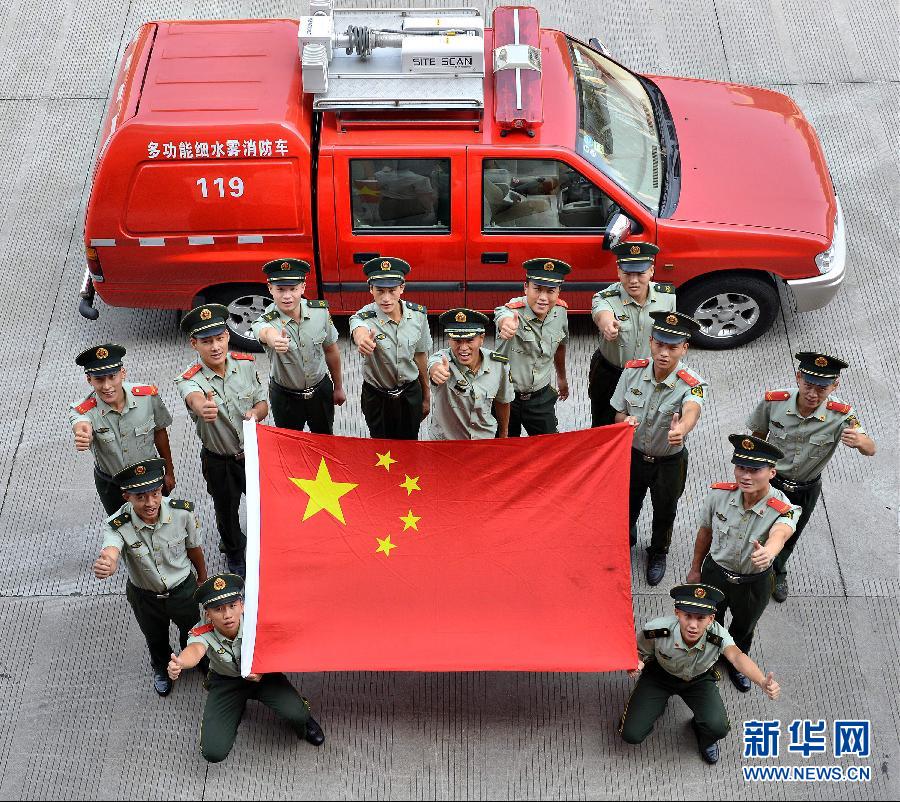  9月25日，武警浙江嘉興消防官兵與國旗合影。