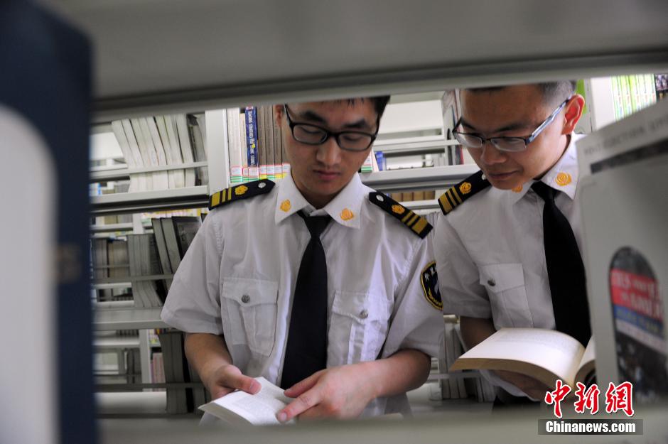 5月8日，武漢輕工大學(xué)圖書館保安吳濤與江力在圖書館交流學(xué)習(xí)。