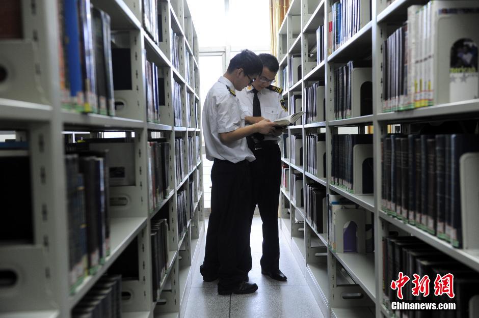 5月8日，武漢輕工大學(xué)保安吳濤與江力在圖書館交流學(xué)習(xí)。中新社發(fā) 張暢 攝