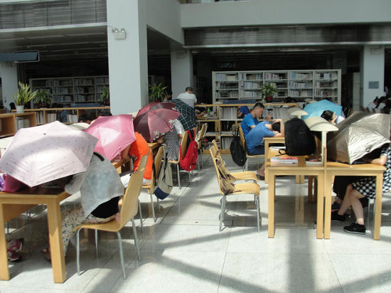 圖書館內(nèi)撐傘讀書的民眾。