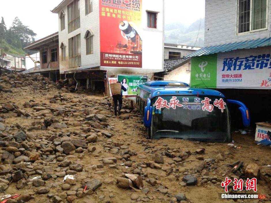 圖為山洪泥石流導(dǎo)沖進鄉(xiāng)鎮(zhèn)街道，導(dǎo)致客車被埋。