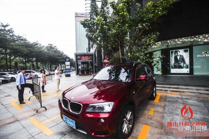 一輛停在停車位上的寶馬轎車，被墜落的樹枝砸中，樹枝徑直插入車內(nèi)，現(xiàn)場(chǎng)引發(fā)不少市民圍觀拍照。