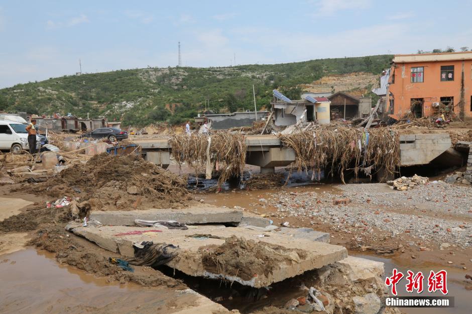 圖為洪水過后，坍塌的橋梁上遺落大量雜草。