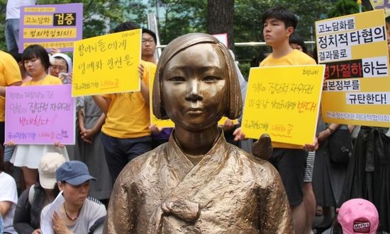 7月2日，在韓國首爾的日本駐韓國大使館前，民眾在慰安婦少女像旁手持標語參加抗議活動。
