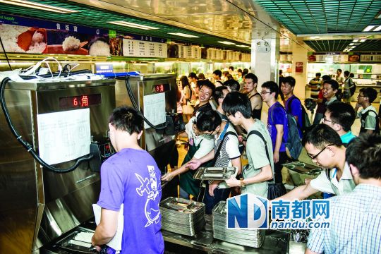 昨日，華南理工大學(xué)一食堂內(nèi)，學(xué)生們正在使用新安裝的自動打飯機(jī)打飯。中新社發(fā)