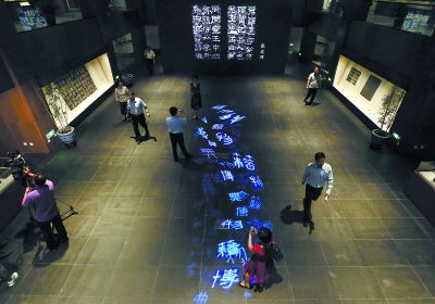昨天，在國(guó)家典籍博物館內(nèi)，通過藝術(shù)投影技術(shù)呈現(xiàn)在展廳地面上的“漢字歷史長(zhǎng)河”，引得參觀者駐足觀看。