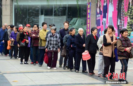 圖為10月28日，在江西九江市一家羊絨皮草服裝服飾博覽會現(xiàn)場，老人們正在頂著寒風(fēng)排隊等待領(lǐng)取10元代金劵。