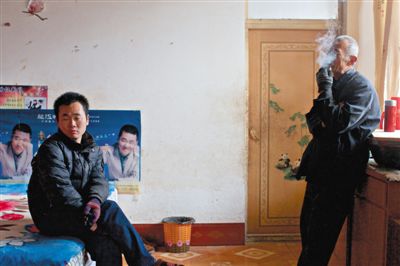 父親抽煙，兒子不語。逃跑的越南新娘，給袁迎賓父子帶來的是失落。新京報(bào)記者 周崗峰 攝