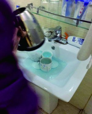酒店服務員用潔廁液刷燒水壺和茶杯。