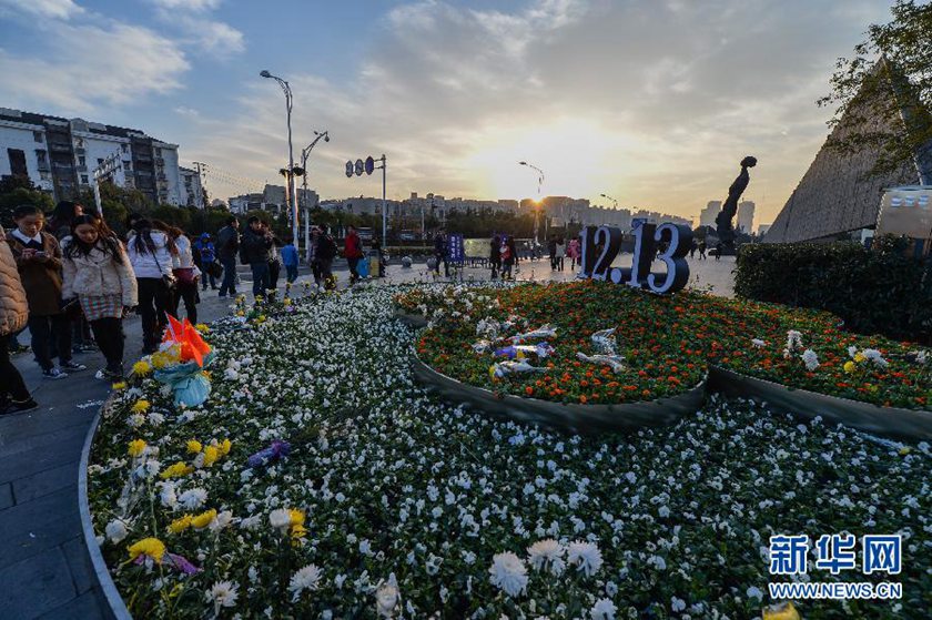 12月14日,觀眾在侵華日軍南京大屠殺遇難同胞紀(jì)念館前的“12·13”花壇上擺放鮮花祭奠遇難同胞。新華社記者 沈鵬 攝