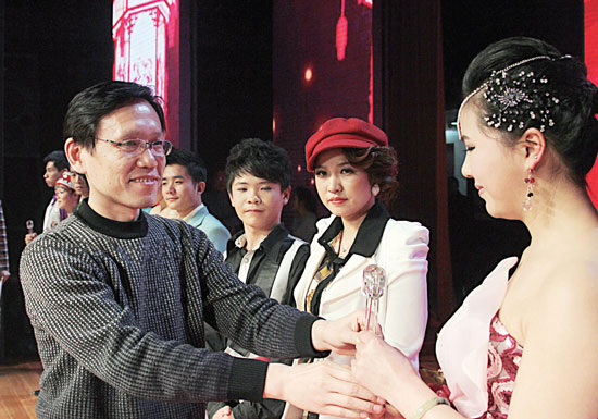 2013年2月1日，《對(duì)9當(dāng)歌》總決賽在鄭州開(kāi)唱。圖為東方今報(bào)副社長(zhǎng)胡楊為選手頒獎(jiǎng)