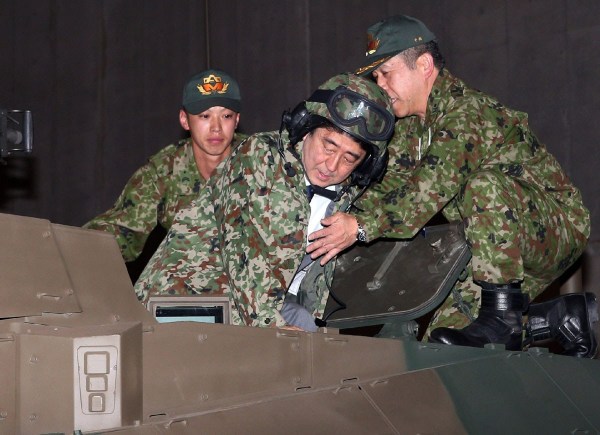 當地時間4月27日，日本千葉市，日本首相安倍晉三他身穿迷彩服頭戴鋼盔的登上展出中的日本陸上自衛(wèi)隊最新