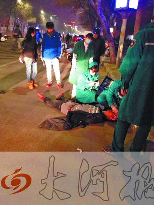 醉漢躺在地上，醫(yī)護(hù)人員對其進(jìn)行檢查。
